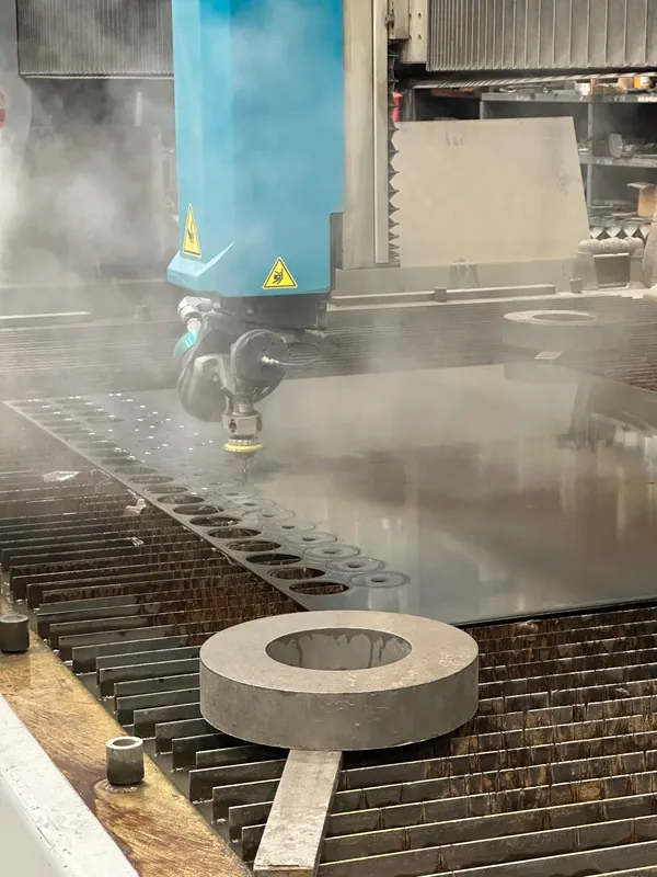 Waterjet cutting head slicing tubesheet hole pattern in exotic alloy plate